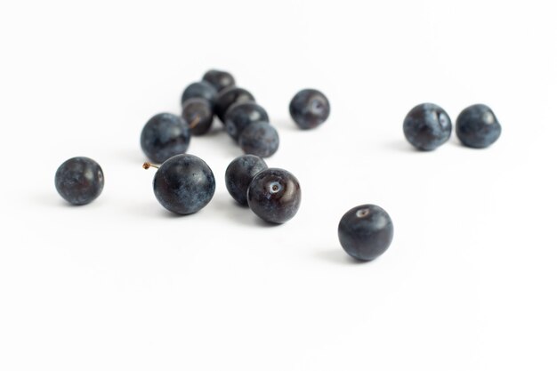 Vorderansicht frische schwarze Dornen saure und dunkle Früchte auf dem weißen Hintergrundfrucht frischen Sommersaftwein