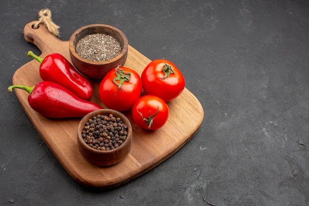 Vorderansicht frische Tomaten mit Gewürzen und rotem Pfeffer auf dunklem Raum