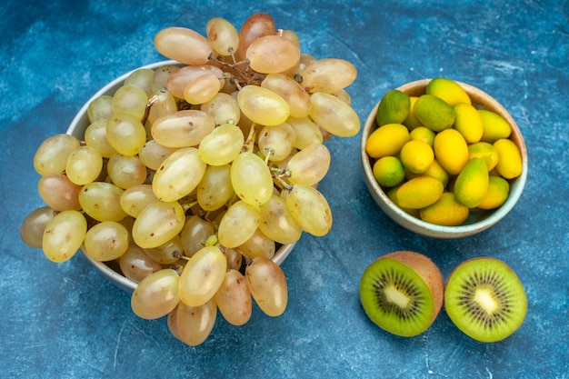 Vorderansicht frische trauben innerhalb platte auf blauem saft reife farbfrucht reifes foto