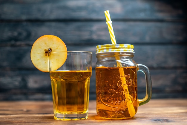 Vorderansicht frischer Apfelsaft in Dose und Glas auf braunem Holzschreibtisch Fotococktail Fruchtgetränk Farbe