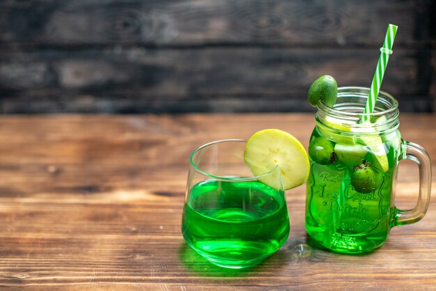 Vorderansicht frischer Feijoa-Saft in der Dose und im Glas auf dem dunklen Bar-Fruchtcocktail-Farbfoto