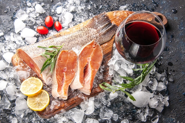 Vorderansicht frischer Fischscheiben mit Wein und Eis auf dunklem Hintergrund Restaurant Abendessen Mahlzeit Meeresfrüchte Gesundheit Fleisch Meeresküche