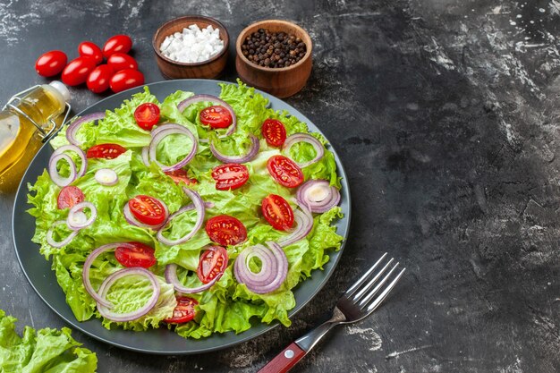 Vorderansicht frischer Gemüsesalat mit grünen Salatzwiebeln und Tomaten auf dem grauen Hintergrund Mahlzeit Salat Lebensmittel Gesundheit Foto Diät reife Farbe