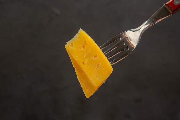 Vorderansicht frischer Käse in Scheiben geschnitten auf Gabel dunkle Farbe Snack Foto Frühstück knusprige Mahlzeit