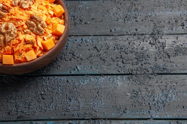 Vorderansicht frischer Karottensalat geriebener Salat mit Walnüssen und Knoblauch auf dem dunklen Schreibtisch Diätsalat Gesundheit Farbe Nuss