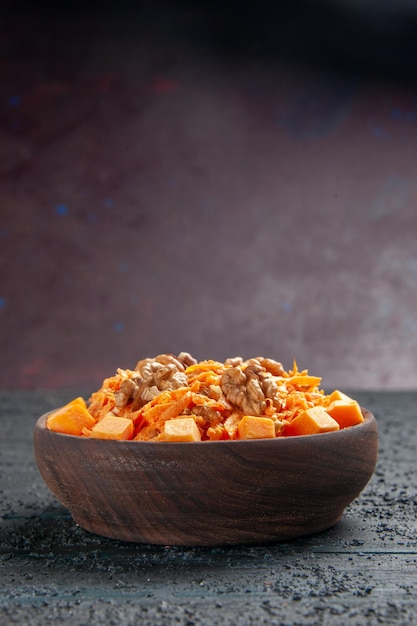 Vorderansicht frischer Karottensalat geriebener Salat mit Walnüssen und Knoblauch auf dunklem Schreibtisch Diätsalat Farbe Nussgesundheit