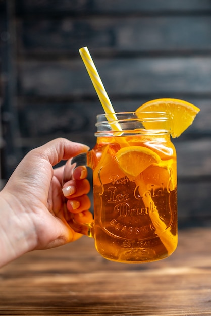 Vorderansicht frischer orangensaft im inneren kann auf dunklen barfrüchten farbfoto-cocktailgetränk