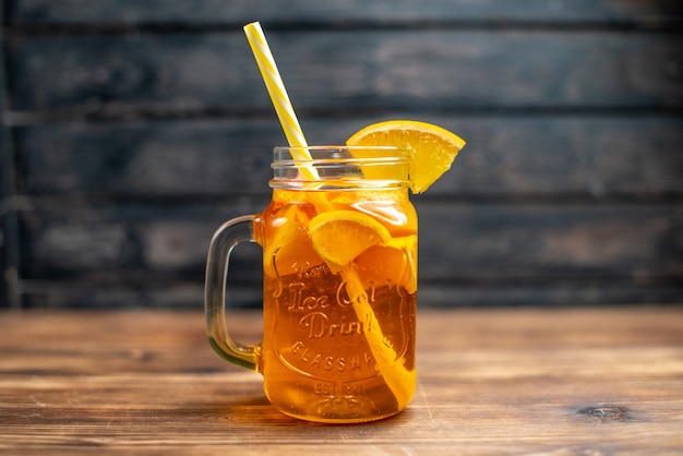 Vorderansicht frischer Orangensaft in der Dose mit Strohhalm auf dunklem Fruchtfarbfoto-Cocktailgetränk