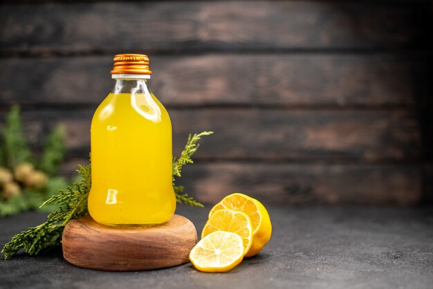 Vorderansicht frischer Orangensaft in Flasche auf Holzbrett