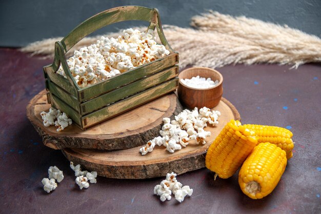 Vorderansicht frisches Popcorn mit gelben Hühneraugen auf dem dunklen Oberflächen-Snack-Popcorn-Mais-Essen