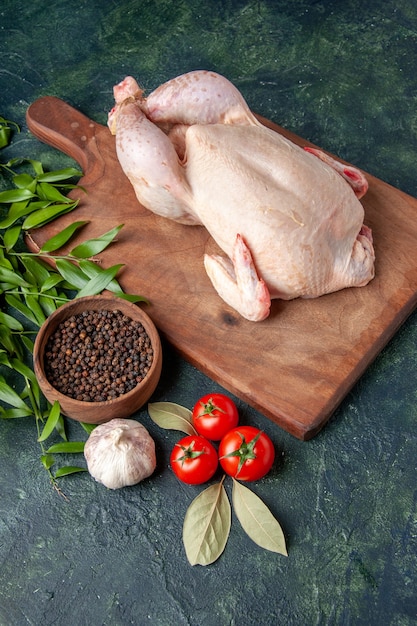 Vorderansicht frisches rohes Huhn mit Tomaten auf dunkelblauer Küche Restaurant Mahlzeit Tierfoto Bauernhof Fleisch Farbe Lebensmittel Huhn