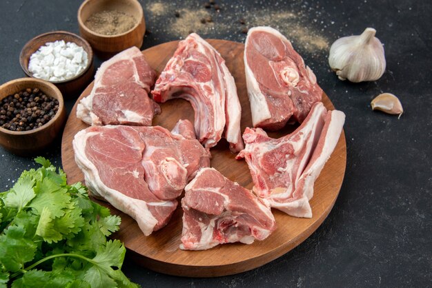 Vorderansicht Frischfleischscheiben rohes Fleisch mit Gewürzen auf grauem Hintergrund Essen Frische Kuh Essen Küche Tier