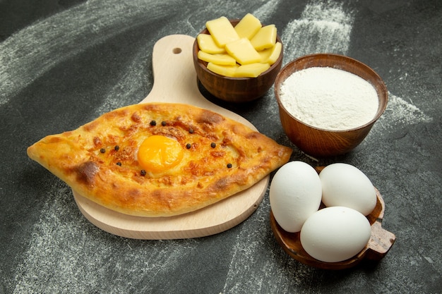 Vorderansicht gebackenes Eierbrot köstliches Teigbrötchen auf dem dunklen Schreibtisch