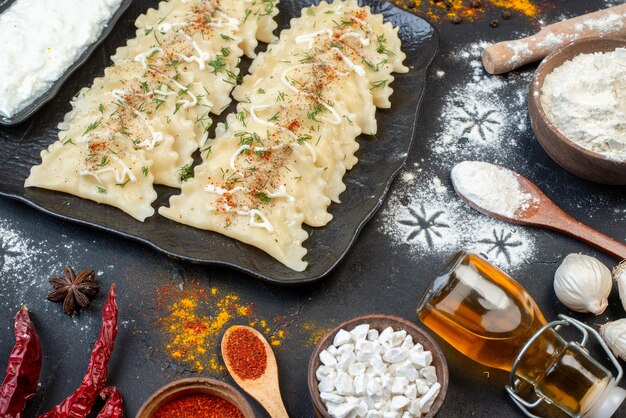 Kostenloses Foto vorderansicht gekochte fleischknödel mit verschiedenen zutaten auf dunklem hintergrund gemüsegericht mahlzeit farbe teig abendessen pfeffer