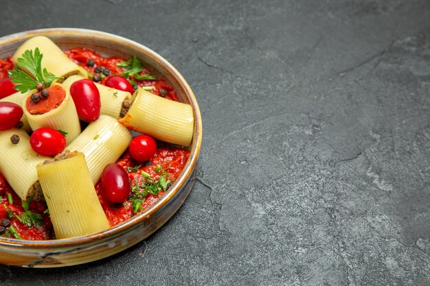 Vorderansicht gekochte italienische Pasta köstliche Mahlzeit mit Fleisch und Tomatensauce auf dem grauen Hintergrund Teig Pasta Fleischsauce Essen