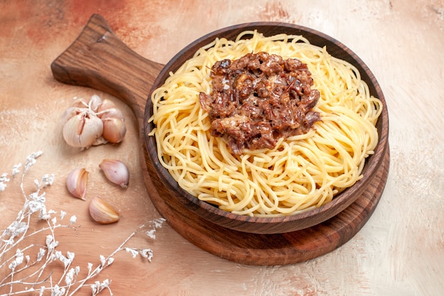 Vorderansicht gekochte Spaghetti mit Hackfleisch auf Holzschreibtisch Nudelteiggericht Gewürze