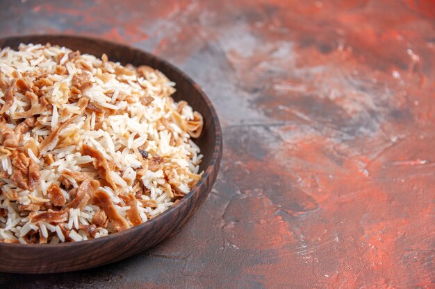 Vorderansicht gekochter Reis mit Teigscheiben auf dunklem Oberflächengericht Mahlzeit Essen ph