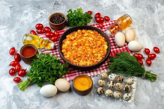 Vorderansicht gekochtes Frühstück Spiegeleier und Tomaten mit verschiedenen Zutaten auf weißem Hintergrund Morgen Mittagessen Essen Brot Familie Farbe Mahlzeit