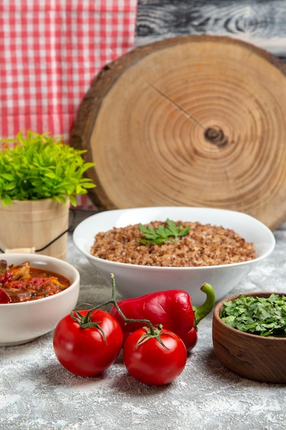 Vorderansicht gemüsesuppe mit buchweizen und tomaten auf weißem raum