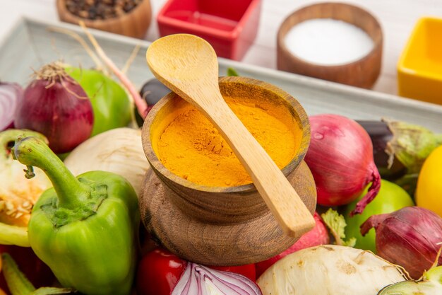 Vorderansicht Gemüsezusammensetzung mit Gewürzen auf weißem Hintergrund Farbfoto gesundes Leben Salatmahlzeit reifes Gemüse