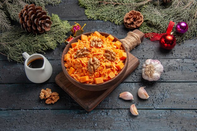 Vorderansicht geriebener Karottensalat mit Walnüssen auf dunkelblauem Hintergrund Gesundheit Salat Farbe Diät Lebensmittel Nuss