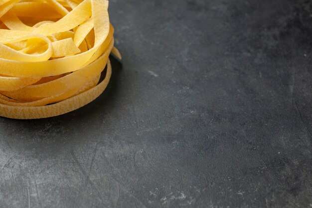 Vorderansicht gerolltes Teigstück auf dunklem Hintergrund Teig Mahlzeit Essen Pasta Dunkelheit Küche Freiraum pasta