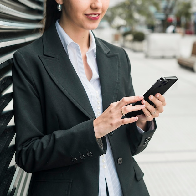 Vorderansicht-Geschäftsfrau, die ihr Smartphone prüft