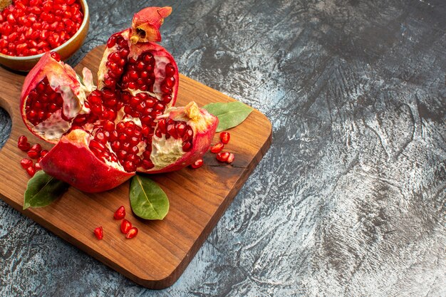 Vorderansicht geschnittene Granatäpfel frische rote Früchte auf dem dunklen Tisch rote frische Beere