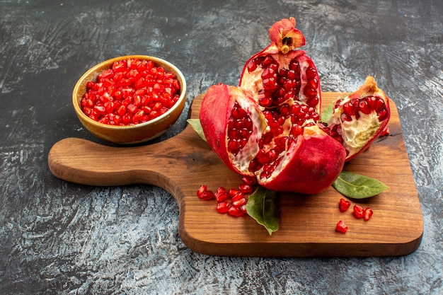 Vorderansicht geschnittene Granatäpfel frische rote Früchte auf hellem Tisch rote frische Beerenfrucht