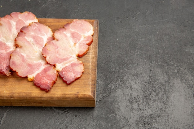 Vorderansicht geschnittener Schinken auf Holzschreibtisch und graues Foto Fleisch Essen Mahlzeit rohes Schwein