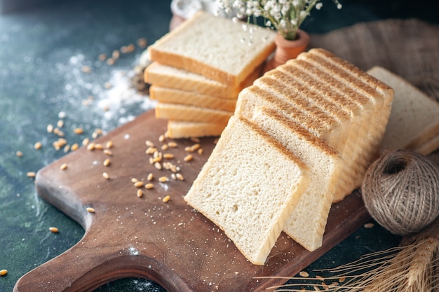 Vorderansicht geschnittenes Weißbrot auf dunklem Hintergrund Brötchenteig Bäckerei Tee Essen Frühstück Morgengebäck