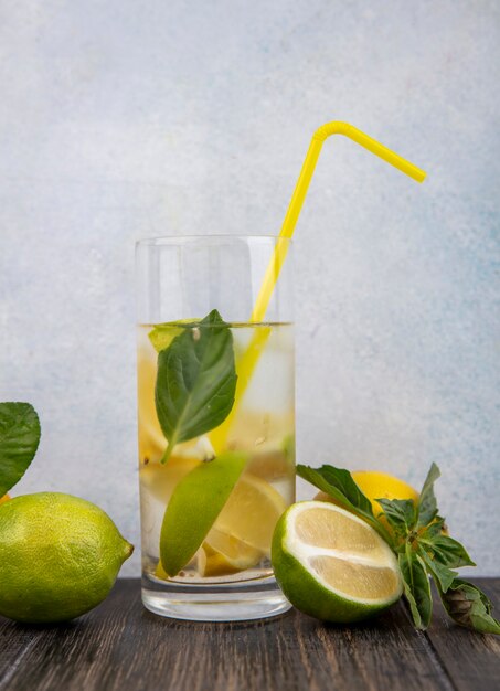 Vorderansicht Glas Wasser mit gelber Strohminze Zitrone und Limettenschnitzen