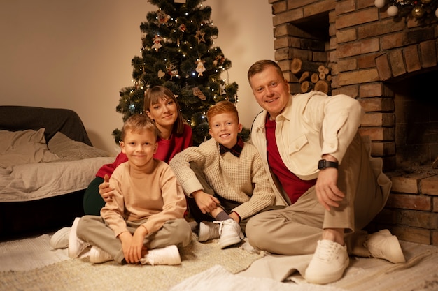 Vorderansicht glückliche Familie, die auf dem Boden sitzt