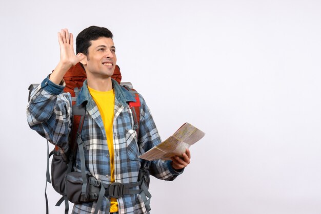 Vorderansicht glücklicher junger Camper mit Rucksack, der Karte hält, die jemanden anruft