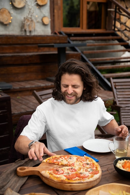 Vorderansicht glücklicher Mann, der Pizza isst