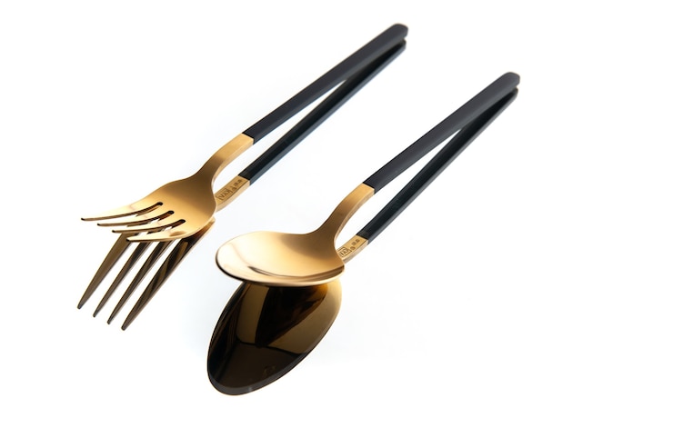 Kostenlose Foto vorderansicht goldener bestecklöffel und gabel auf weißem hintergrund