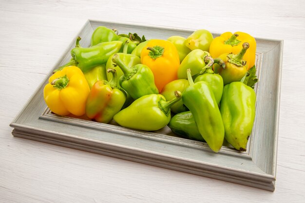 Vorderansicht grüne paprika im rahmen auf weißem pfefferfarbe reifes pflanzengemüsesalatfoto