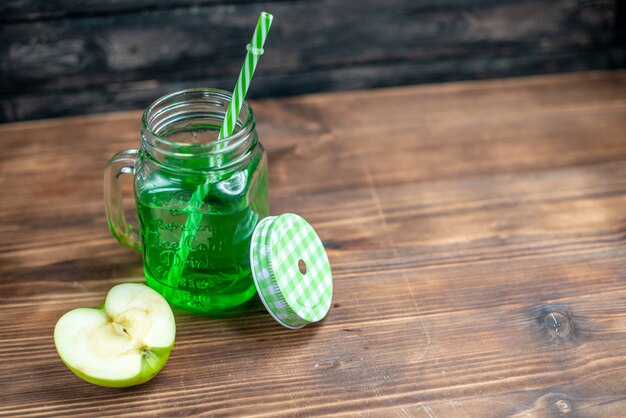 Vorderansicht grüner Apfelsaft in der Dose mit frischer Apfelscheibe auf dunkler Fruchtgetränk-Foto-Cocktailbar-Farbe