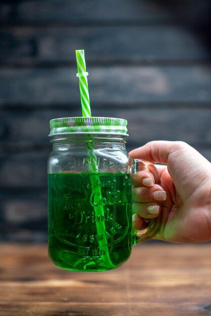 Vorderansicht grüner Apfelsaft in der Dose mit Strohhalm auf Holzschreibtisch trinken Foto Cocktailbar Fruchtfarbe