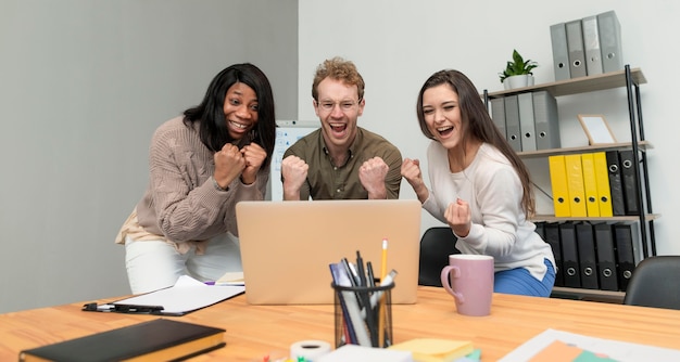 Vorderansicht Gruppe von jungen Leuten, die sich bei der Arbeit zusammenschließen