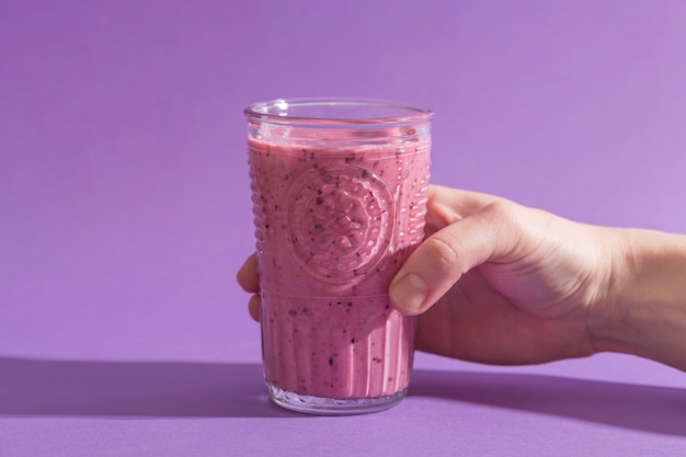 Vorderansicht Hand, die Glas mit rosa Smoothie hält