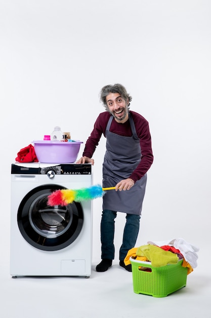 Vorderansicht Haushälterin Mann Reinigung Waschmaschine mit Staubtuch Wäschekorb auf weißem Hintergrund