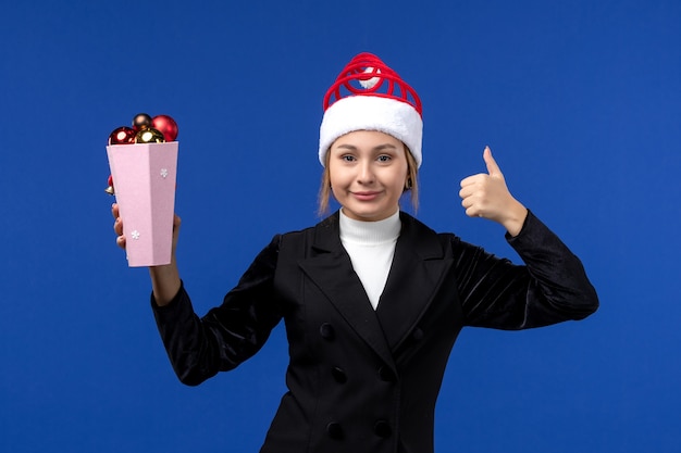 Vorderansicht hübsche Frau, die Baumspielzeug auf blauer Neujahrsfeiertagsfeiertagsfrau der blauen Wand hält