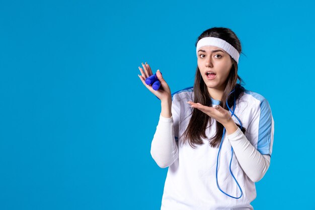 Vorderansicht hübsche Frau in der Sportkleidung mit Springseil auf Blau