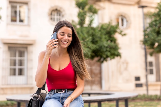 Vorderansicht hübsche junge Frau, die am Telefon spricht