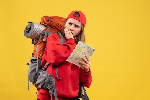 Vorderansicht hübscher weiblicher Reisender mit Rucksack, der Karte wundert