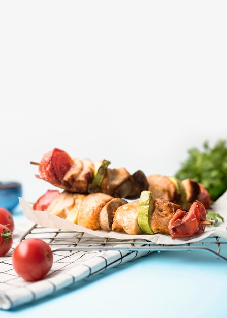 Vorderansicht-Hühnchen-Spieße auf Pergamentpapier mit Kirschtomaten