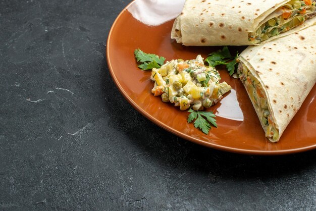 Vorderansicht in Scheiben geschnittenes shaurma leckeres Fleischsandwich in der Platte auf dunklem Schreibtisch Burger Sandwich Brot Pita