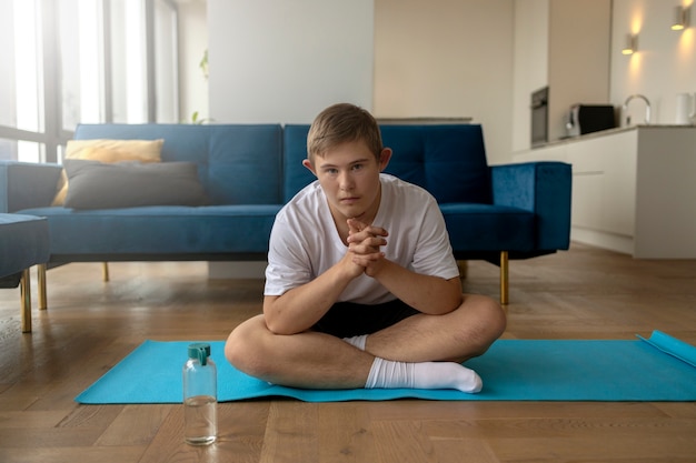 Kostenloses Foto vorderansicht junge, der zu hause yoga macht