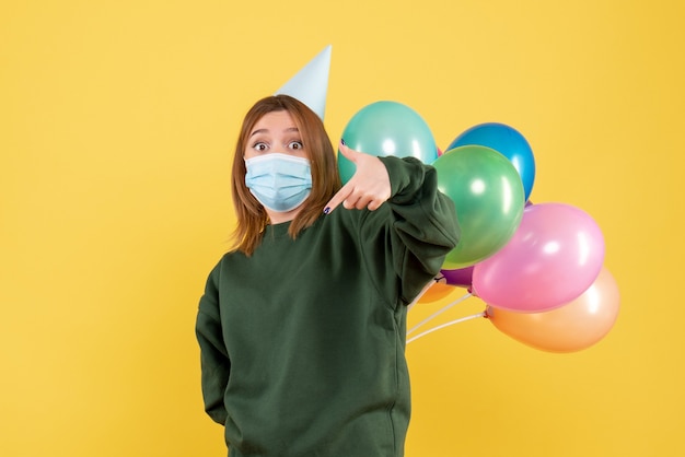 Vorderansicht junge Frau, die bunte Luftballons hält